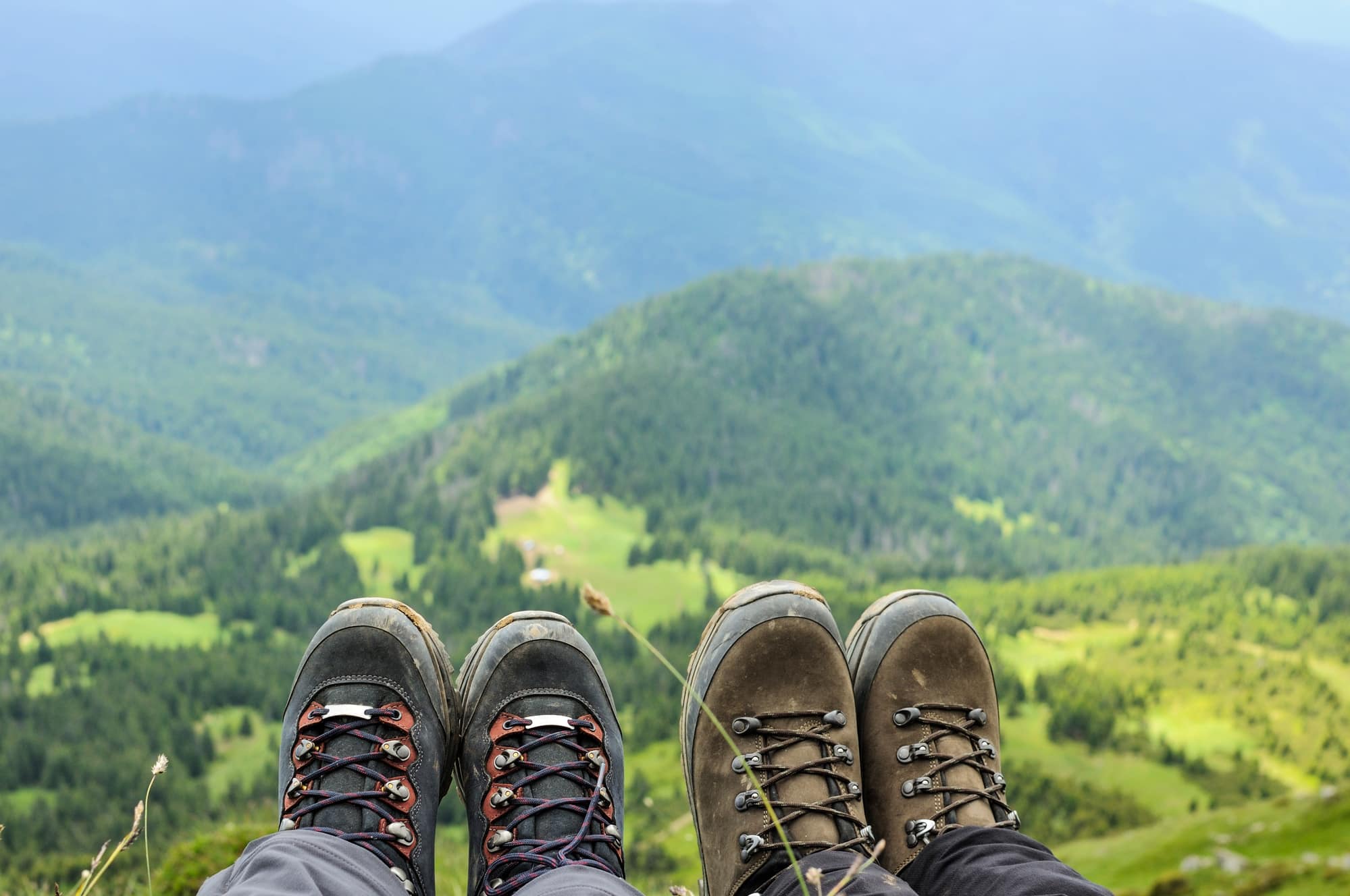 Hiking boots of traveler sitting on high mountain top