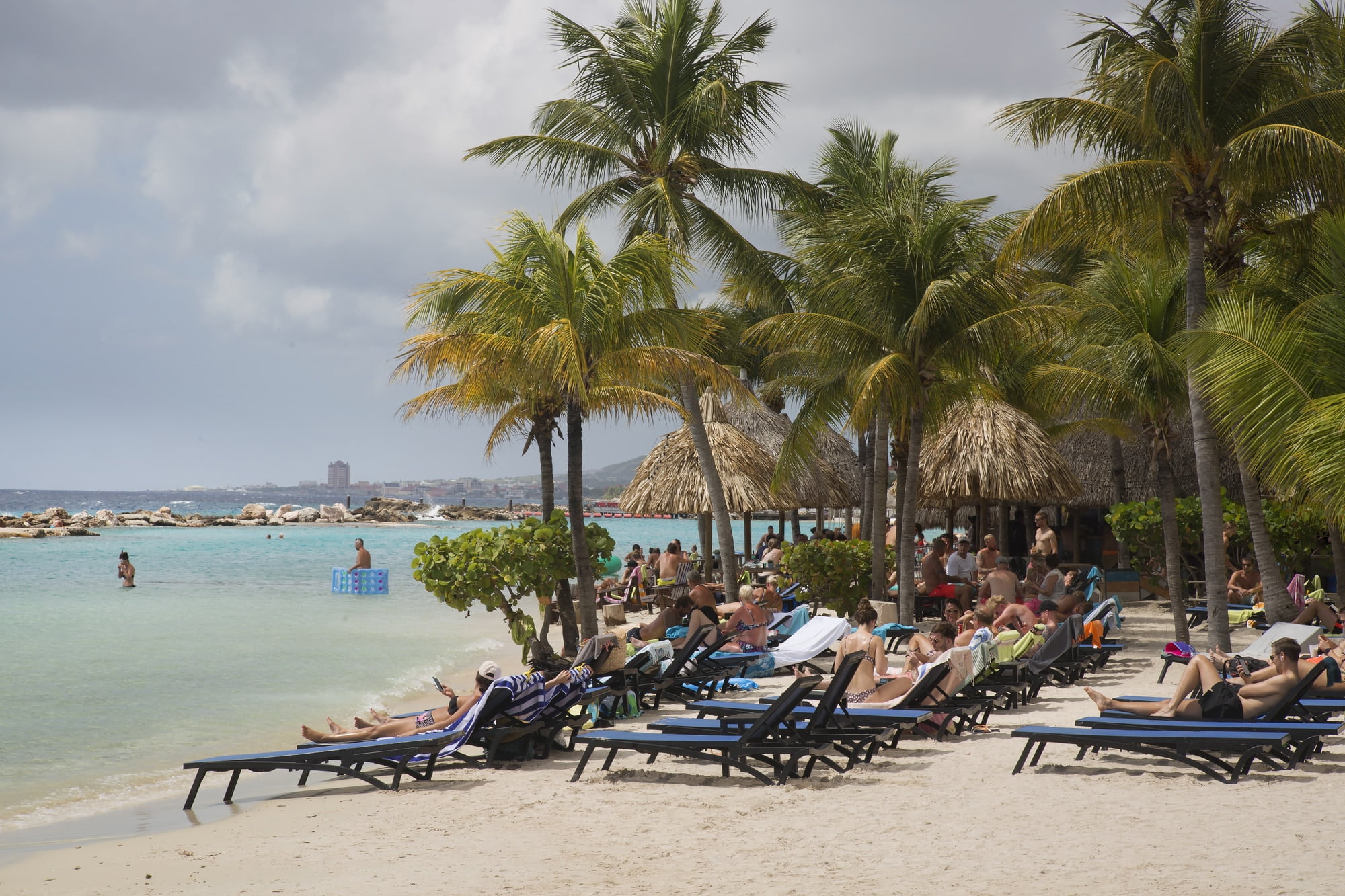 Curacao. Beautiful beach with palm trees and tourists