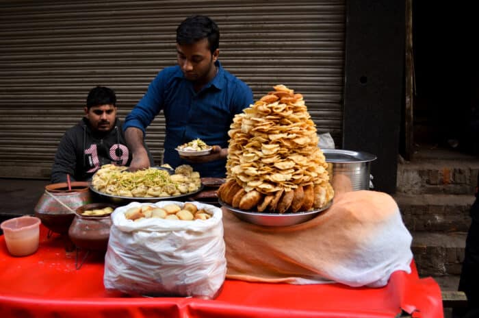 Gadehandler tilbereder og serverer krydret Chaat i det gamle Delhi