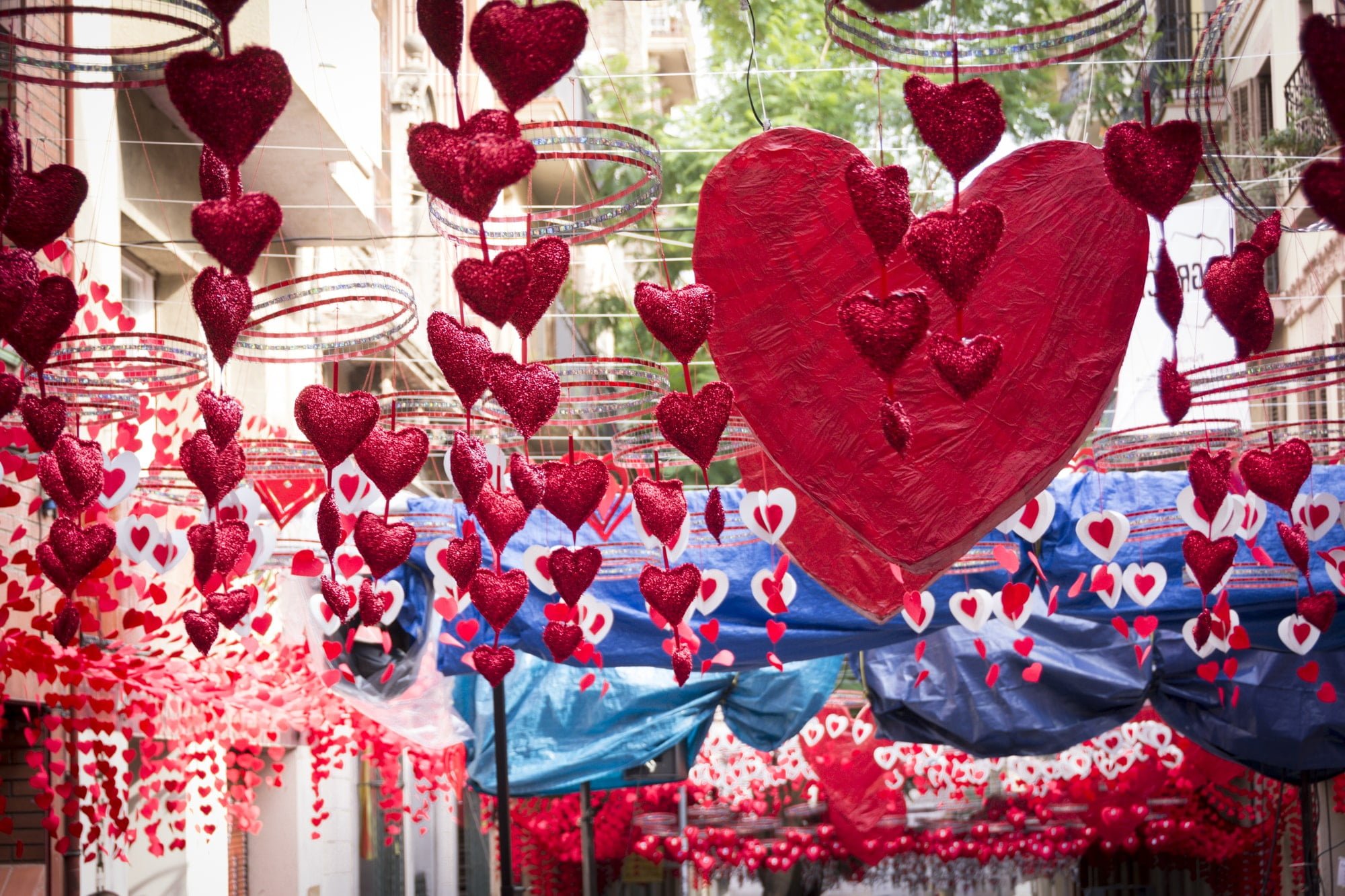 Red hearts hanging and moving in Gracia district, Barcelona