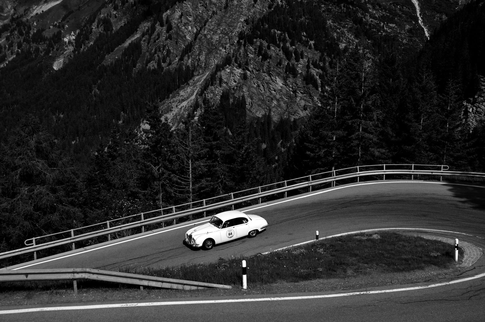 A white Jaguar S-Type takes part to the Summer Marathon classic car race near Maloja Pass, Switzerland. This car was built in 1965
